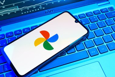 Prag, Çek Cumhuriyeti - 08 18 2025: Bir klavyede bir cep telefonu Google Photos logosunu görüntüler. Google Fotoğrafları fotoğraf ve videoları saklamak ve düzenlemek için bir platformdur.