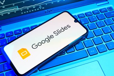 Prag, Çek Cumhuriyeti - 08 18 2025: Klavyede bir cep telefonu Google Slides logosunu görüntüler. Google Slides sunumlar ve slayt gösterileri oluşturmak için bir platformdur.