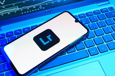 Prag, Çek Cumhuriyeti - 08 18 2025: Klavyede bir cep telefonu Lightroom logosunu gösteriyor. Lightroom fotoğraf düzenleme ve yönetim için bir yazılımdır..