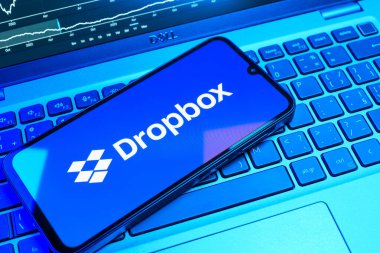Prag, Çek Cumhuriyeti - 08 18 2025: Klavyede bir cep telefonu Dropbox logosu sergiler. Dropbox bulut depolama ve dosya paylaşımı için bir platformdur.