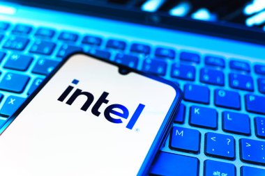 Prag, Çek Cumhuriyeti - 08 19 2025: Intel logosunu gösteren klavyenin üzerinde duran bir cep telefonunun yakından görüntüsü. Intel işlemci ve bilgisayar donanımı üreten bir teknoloji şirketidir..