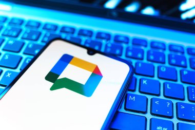 Prag, Çek Cumhuriyeti - 08 19 2025: Google Chat logosunu gösteren klavyenin üzerinde duran cep telefonunun yakından görüntüsü. Google Chat mesajlaşma ve takım işbirliği için bir platformdur.