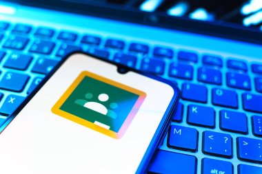 Prag, Çek Cumhuriyeti - 08 19 2025: Google Sınıfı logosunu gösteren klavyenin üzerinde duran cep telefonunun yakından görüntüsü. Google Sınıfı, sınıfları ve eğitim içeriğini yönetmek için bir platformdur.