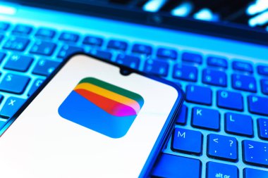 Prag, Çek Cumhuriyeti - 08 19 2025: Google Cüzdan logosunu gösteren klavyenin üzerinde duran cep telefonunun yakından görüntüsü. Google Cüzdanı dijital ödeme yöntemlerini depolamak ve kullanmak için bir platformdur.