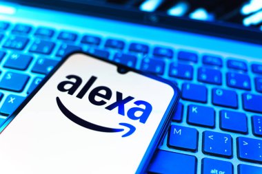 Prag, Çek Cumhuriyeti - 08 19 2025: Klavyenin üzerinde Alexa logosunu gösteren cep telefonunun yakın çekim görüntüsü. Alexa akıllı aygıtlar ve servisler için ses asistanıdır.