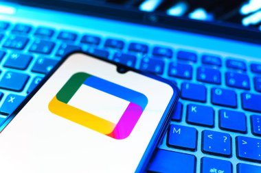 Prag, Çek Cumhuriyeti - 08 19 2025: Google TV logosunu gösteren klavyenin üzerinde duran bir cep telefonunun yakından görüntüsü. Google TV film, program ve uygulamalar için bir platformdur..