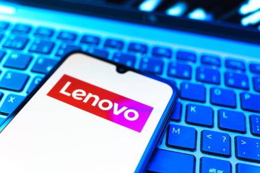 Prag, Çek Cumhuriyeti - 08 19 2025: Klavyede duran ve Lenovo logosunu gösteren bir cep telefonunun yakından görüntüsü. Lenovo bilgisayar ve elektronik üreten bir teknoloji şirketidir..