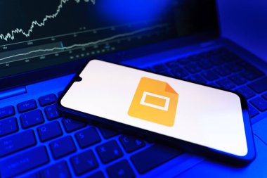 Prag, Çek Cumhuriyeti - 09 02 2025: Google Slides logosunu gösteren dizüstü bilgisayarlı telefon. Google Slides sunumlar ve slayt gösterileri oluşturmak için bir platformdur.