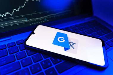 Prag, Çek Cumhuriyeti - 09 02 2025: Google Translate logosunu gösteren dizüstü bilgisayarlı telefon. Google Çevirisi metni ve konuşmayı diller arası çevirmek için bir platformdur..