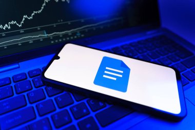 Prag, Çek Cumhuriyeti - 09 02 2025: Google Docs logosunu gösteren dizüstü bilgisayarlı telefon. Google Docs metin belgeleri oluşturmak ve düzenlemek için bir platformdur.