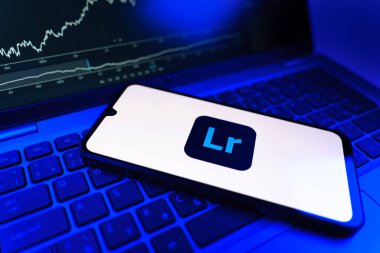 Prag, Çek Cumhuriyeti - 09 02 2025: Lightroom logosunu gösteren dizüstü bilgisayarlı telefon. Lightroom fotoğraf düzenleme ve yönetim için bir yazılımdır..