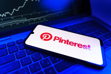 Prag, Çek Cumhuriyeti - 09 02 2025: Pinterest logosunu gösteren dizüstü bilgisayarlı telefon. Pinterest fikirleri görsel olarak keşfetmek ve kaydetmek için bir platformdur..