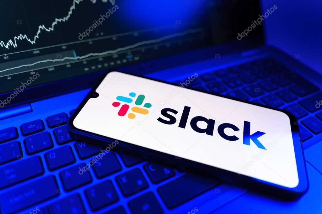 Prague, Czechia - 09 02 2025: Phone on laptop with stock chart showing Slack logo. Slack is a platform for team messaging and workplace communication.