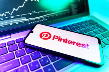 Prag, Çek Cumhuriyeti - 09 02 2025: Pinterest logosunu gösteren dizüstü bilgisayarlı telefon. Pinterest fikirleri görsel olarak keşfetmek ve kaydetmek için bir platformdur..