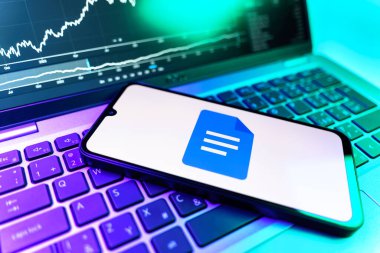 Prag, Çek Cumhuriyeti - 09 02 2025: Google Docs logosunu gösteren dizüstü bilgisayarlı telefon. Google Docs metin belgeleri oluşturmak ve düzenlemek için bir platformdur.