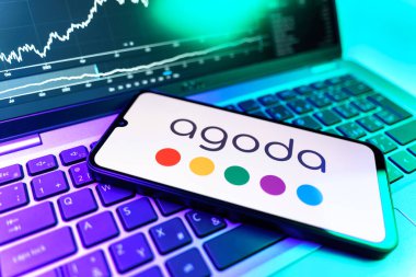 Prag, Çek Cumhuriyeti - 09 02 2025: Agoda logosunu gösteren dizüstü bilgisayarlı telefon. Agoda, otelleri ve seyahat yerlerini ayırtmak için bir platform..