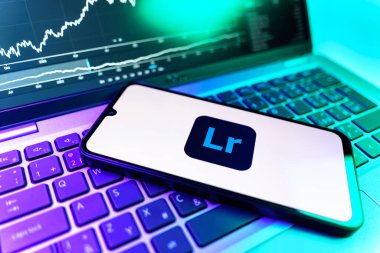 Prag, Çek Cumhuriyeti - 09 02 2025: Lightroom logosunu gösteren dizüstü bilgisayarlı telefon. Lightroom fotoğraf düzenleme ve yönetim için bir yazılımdır..
