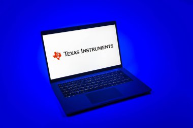 Prag, Çek Cumhuriyeti - 08 12 2025: Tekdüze bir arkaplanda Teksas Enstrümanları logosunu gösteren bir dizüstü bilgisayarın yukarıdan görünüşü. Texas Instruments yarı iletken ve elektronik üreten bir şirket..