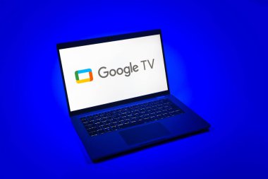Prag, Çek Cumhuriyeti - 08 12 2025: Google TV logosunu gösteren tek bir arkaplanda bir dizüstü bilgisayarın yukarıdan aşağı görüntüsü. Google TV film, program ve uygulamalar için bir platformdur..