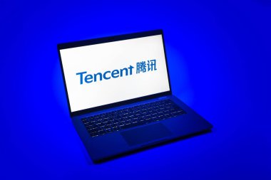Prag, Çek Cumhuriyeti - 08 12 2025: Tek tip arkaplanda Tencent logosunu gösteren bir dizüstü bilgisayarın yukarıdan görünüşü. Tencent internet hizmetleri ve oyunlar sağlayan bir teknoloji şirketidir..