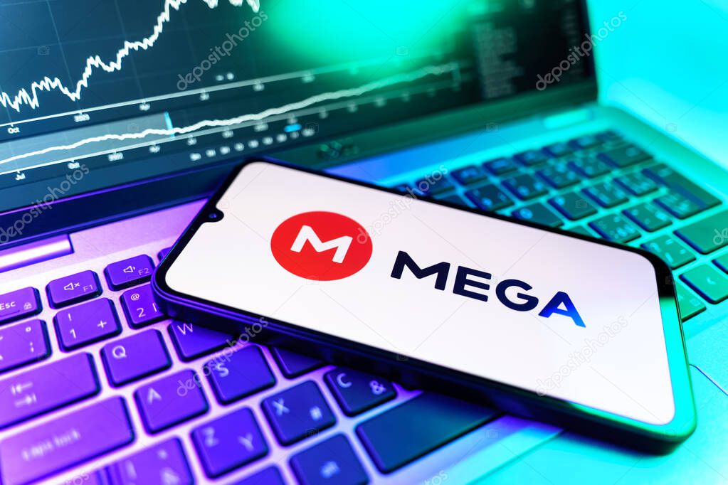 Prague, Czechia - 09 02 2025: Phone on laptop with stock chart showing Mega logo. Mega is a platform for cloud storage with encrypted file sharing.