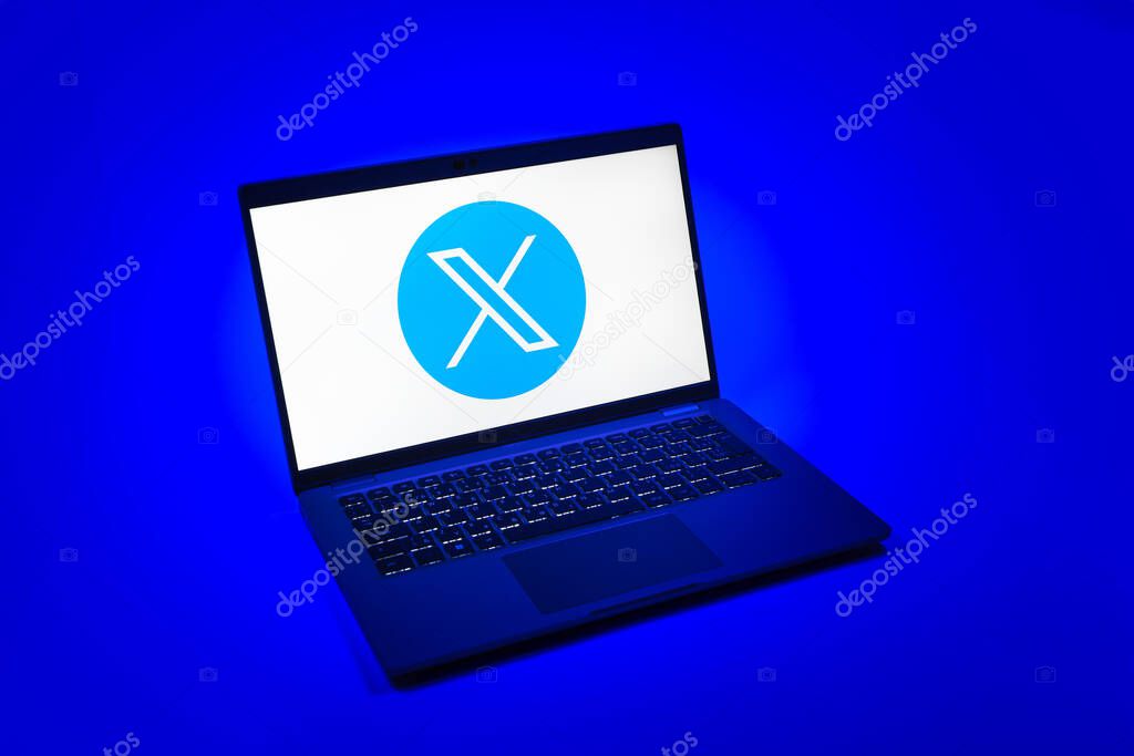 Prague, Czechia - 08 12 2025: A top-down view of a laptop on a uniform background displaying the X logo. X is a platform for sharing short posts and updates.