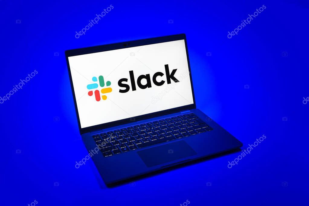 Prague, Czechia - 08 12 2025: A top-down view of a laptop on a uniform background displaying the Slack logo. Slack is a platform for team messaging and workplace communication.