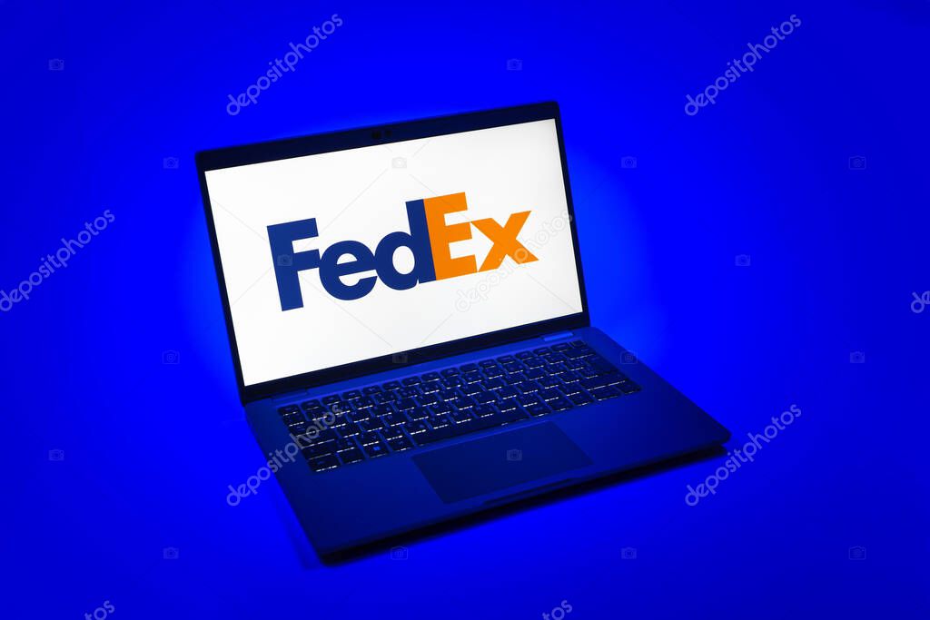 Prague, Czechia - 08 12 2025: A top-down view of a laptop on a uniform background displaying the FedEX logo. FedEX is a logistics company providing shipping and courier services.