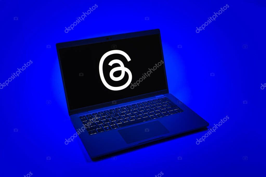 Prague, Czechia - 08 12 2025: A top-down view of a laptop on a uniform background displaying the Threads logo. Threads is a social media platform for sharing short posts and updates.