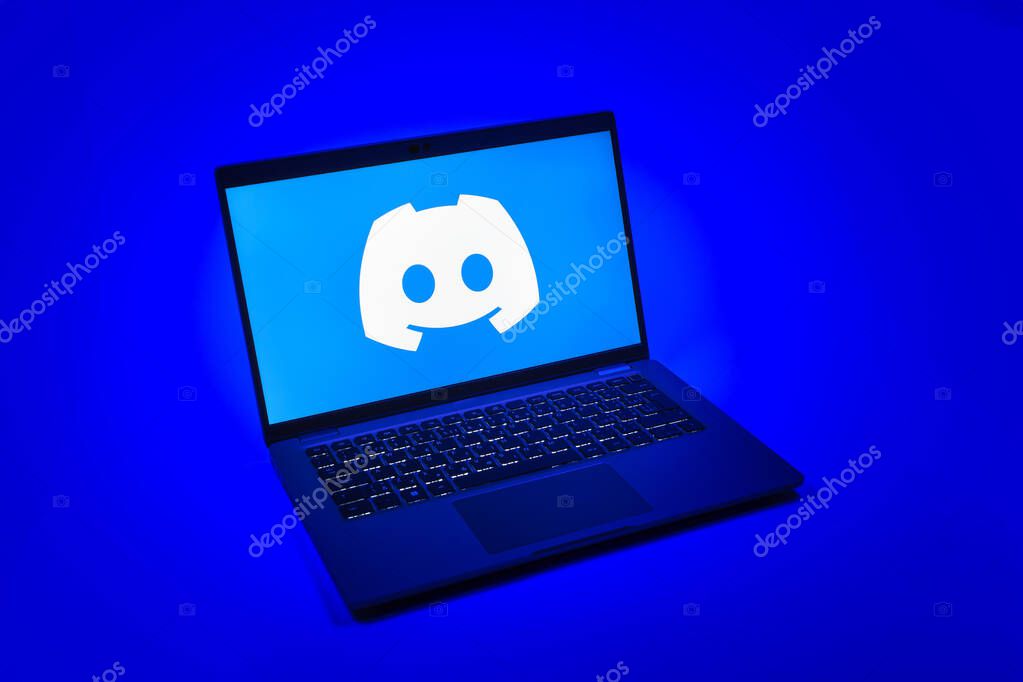 Prague, Czechia - 08 12 2025: A top-down view of a laptop on a uniform background displaying the Discord logo. Discord is a platform for voice, video, and text communication.