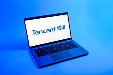Prag, Çek Cumhuriyeti - 08 12 2025: Tek tip arkaplanda Tencent logosunu gösteren bir dizüstü bilgisayarın yukarıdan görünüşü. Tencent internet hizmetleri ve oyunlar sağlayan bir teknoloji şirketidir..