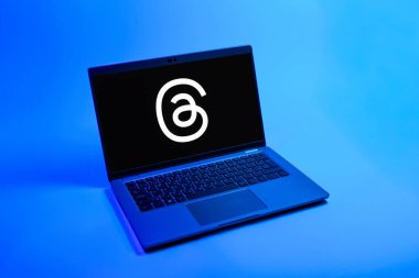 Prag, Çek Cumhuriyeti - 08 12 2025: Dizüstü bilgisayarın tek tip arkaplanda ipliklerin logosunu gösteren yukarıdan aşağı görüntüsü. Tartışmalar, kısa gönderileri ve güncellemeleri paylaşmak için bir sosyal medya platformudur.