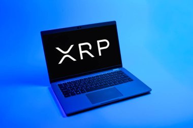 Prag, Çek Cumhuriyeti - 08 12 2025: Tek tip arkaplanda Ripple logosunu gösteren bir dizüstü bilgisayarın yukarıdan görünüşü. Dalgalanma dijital kripto para birimi ve ödeme protokolüdür..