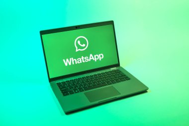 Prag, Çek Cumhuriyeti - 08 12 2025: Tek bir arkaplanda WhatsApp logosunu gösteren bir dizüstü bilgisayarın yukarıdan görünüşü. WhatsApp mesaj, çağrı ve medya göndermek için bir uygulamadır.