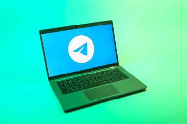 Prag, Çek Cumhuriyeti - 08 12 2025: Tek tip bir arkaplanda Telegram logosunu gösteren bir dizüstü bilgisayarın yukarıdan görünüşü. Telgraf hızlı ve güvenli iletiler için bir uygulamadır.