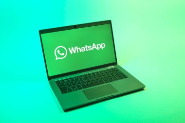 Prag, Çek Cumhuriyeti - 08 12 2025: Tek bir arkaplanda WhatsApp logosunu gösteren bir dizüstü bilgisayarın yukarıdan görünüşü. WhatsApp mesaj, çağrı ve medya göndermek için bir uygulamadır.