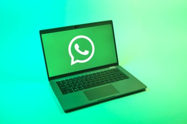 Prag, Çek Cumhuriyeti - 08 12 2025: Tek bir arkaplanda WhatsApp logosunu gösteren bir dizüstü bilgisayarın yukarıdan görünüşü. WhatsApp mesaj, çağrı ve medya göndermek için bir uygulamadır.