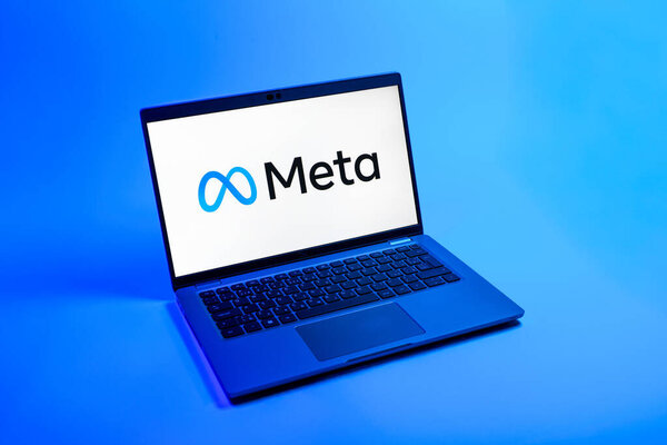 Прага, Чехия - 08 12 2025: Вид сверху на ноутбук на однородном фоне с логотипом Мета. Мета - компания, предлагающая социальные платформы, такие как Facebook и Instagram.