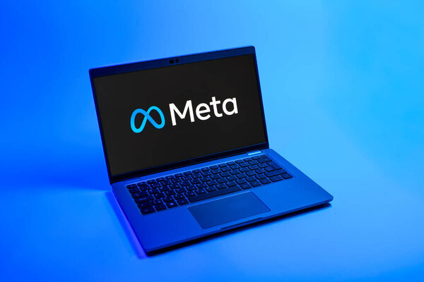 Prague, Czechia - 08 12 2025: A top-down view of a laptop on a uniform background displaying the Meta logo. Meta is a company offering social platforms like Facebook and Instagram.