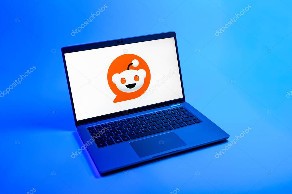 Prague, Czechia - 08 12 2025: A top-down view of a laptop on a uniform background displaying the Reddit logo. Reddit is a platform for discussion, news, and community content.