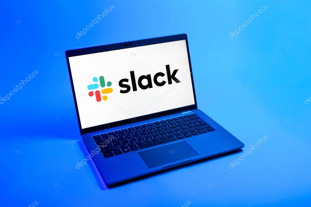Prague, Czechia - 08 12 2025: A top-down view of a laptop on a uniform background displaying the Slack logo. Slack is a platform for team messaging and workplace communication.