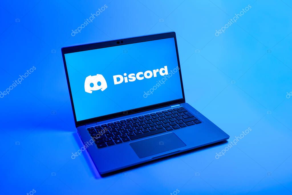 Prague, Czechia - 08 12 2025: A top-down view of a laptop on a uniform background displaying the Discord logo. Discord is a platform for voice, video, and text communication.