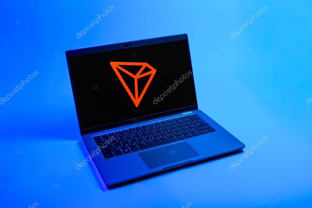 Prague, Czechia - 08 12 2025: A top-down view of a laptop on a uniform background displaying the Tron logo. Tron is a blockchain platform for decentralized applications.