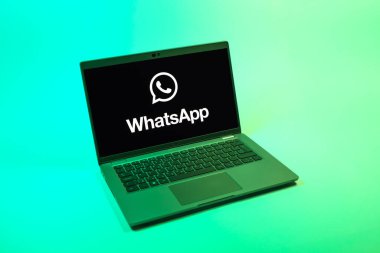 Prag, Çek Cumhuriyeti - 08 12 2025: Tek bir arkaplanda WhatsApp logosunu gösteren bir dizüstü bilgisayarın yukarıdan görünüşü. WhatsApp mesaj, çağrı ve medya göndermek için bir uygulamadır.