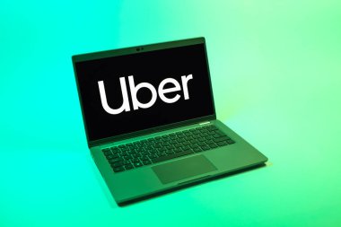 Prag, Çek Cumhuriyeti - 08 12 2025: Uber logosunu gösteren bir dizüstü bilgisayarın tepeden aşağı görüntüsü. Uber ulaşım ve dağıtım hizmetleri için bir gezinti selamlama uygulaması.