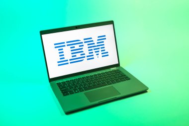 Prag, Çek Cumhuriyeti - 08 12 2025: Tek bir arkaplanda IBM logosunu gösteren bir dizüstü bilgisayarın yukarıdan aşağı görüntüsü. IBM yazılım, donanım ve danışmanlık sunan bir teknoloji şirketidir..
