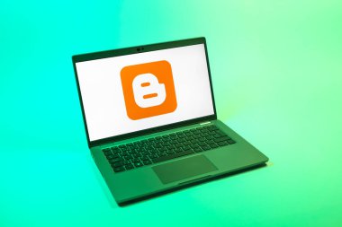 Prag, Çek Cumhuriyeti - 08 12 2025: Blog logosunu gösteren tek tip bir arkaplanda bir dizüstü bilgisayarın yukarıdan aşağı görüntüsü. Blogger blog oluşturma ve yayınlama için bir platformdur.