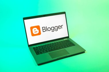Prag, Çek Cumhuriyeti - 08 12 2025: Blog logosunu gösteren tek tip bir arkaplanda bir dizüstü bilgisayarın yukarıdan aşağı görüntüsü. Blogger blog oluşturma ve yayınlama için bir platformdur.