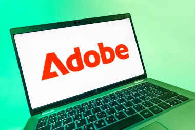 Prag, Çek Cumhuriyeti - 08 12 2025: Adobe logosunu gösteren bir dizüstü bilgisayarın dinamik yakın çekimi. Adobe yaratıcı araçlar ve hizmetler sunan bir yazılım şirketidir..