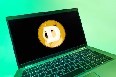 Prag, Çek Cumhuriyeti - 08 12 2025: Dogecoin logosunu gösteren bir dizüstü bilgisayarın dinamik yakın çekimi. Dogecoin, paylaşımcı işlemler için kullanılan bir şifreli para birimidir.
